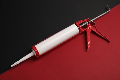 Photo of One glue gun on color background, above view