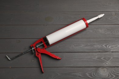 Glue gun on gray wooden background, top view