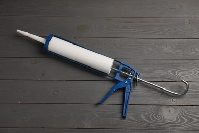 Glue gun on gray wooden background, top view