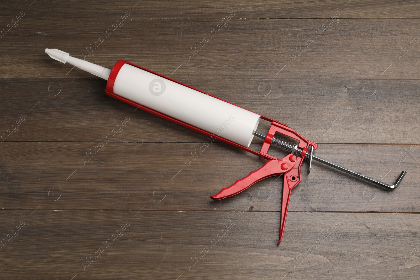 Photo of One glue gun on wooden background, top view. Construction tool