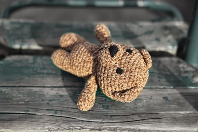 Photo of Lost knitted bear on swing outdoors, closeup