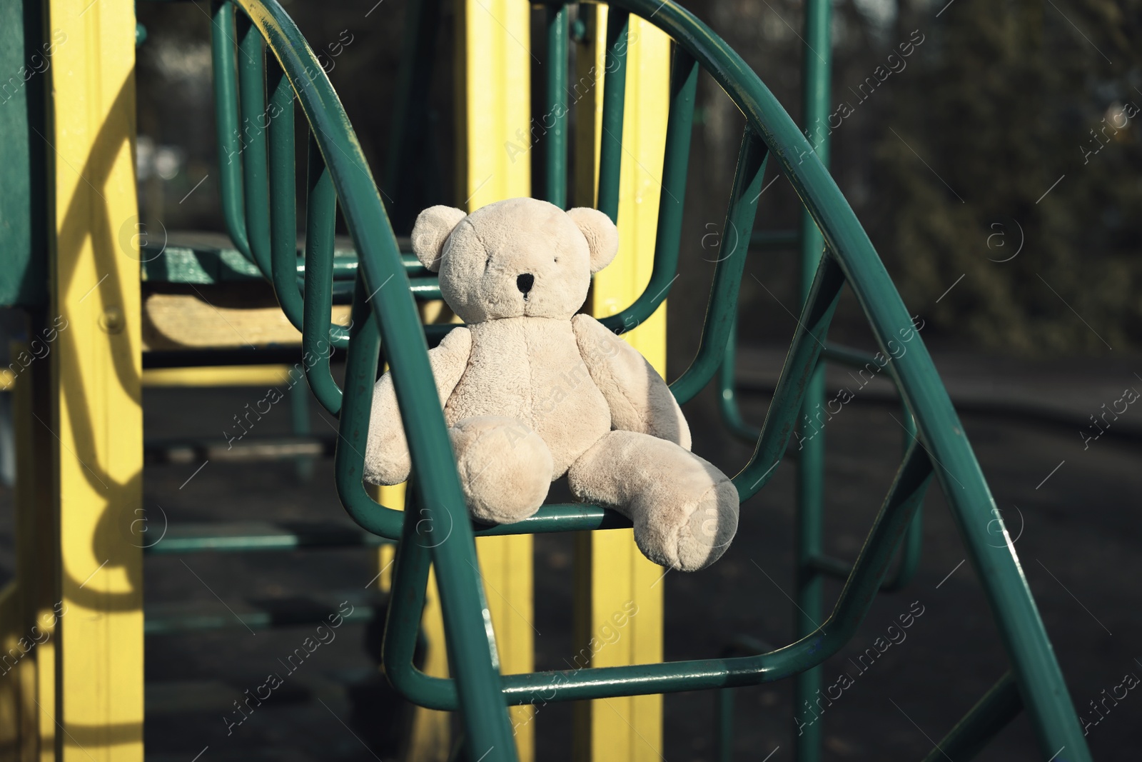 Photo of Lost white teddy bear on playground outdoors