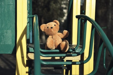 Photo of Lost brown teddy bear on playground outdoors