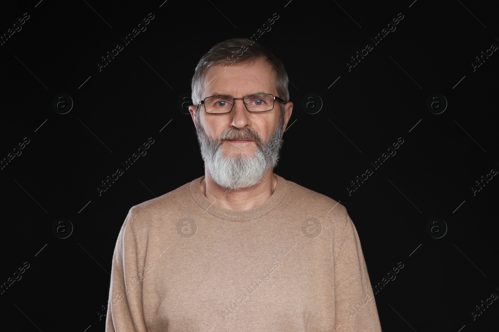 Photo of Portrait of mature man in glasses on black background