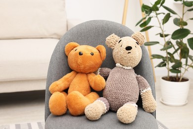 Photo of Two cute toy bears on armchair in room