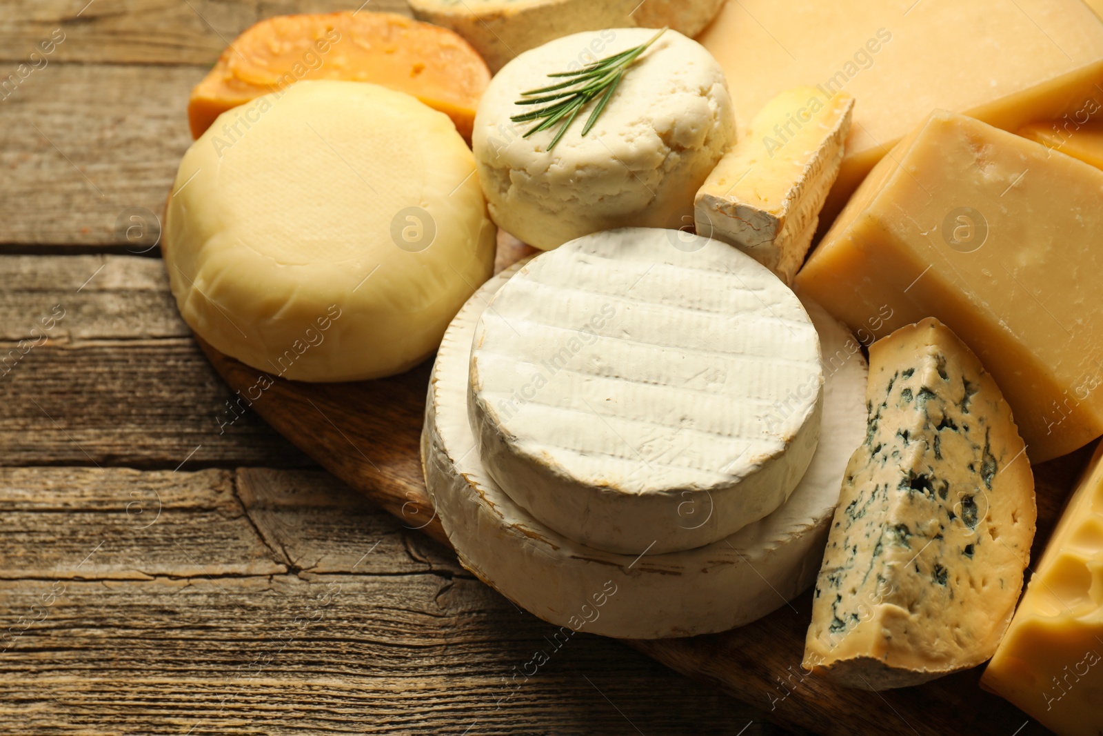 Photo of Different types of cheese on wooden table, closeup