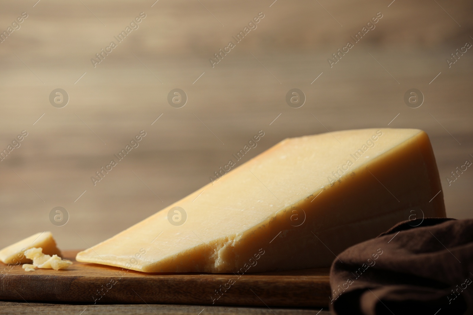 Photo of Piece of delicious cheese on wooden table, closeup