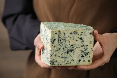 Photo of Woman with piece of delicious cheese, closeup