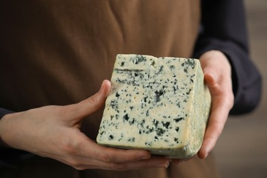 Photo of Woman with piece of delicious cheese, closeup