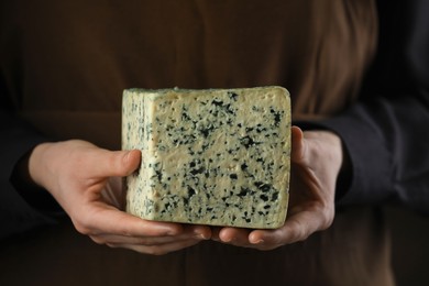 Photo of Woman with piece of delicious cheese, closeup