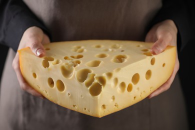 Photo of Woman with piece of delicious cheese, closeup