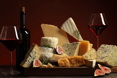 Photo of Different types of cheese, rosemary, figs and wine on table