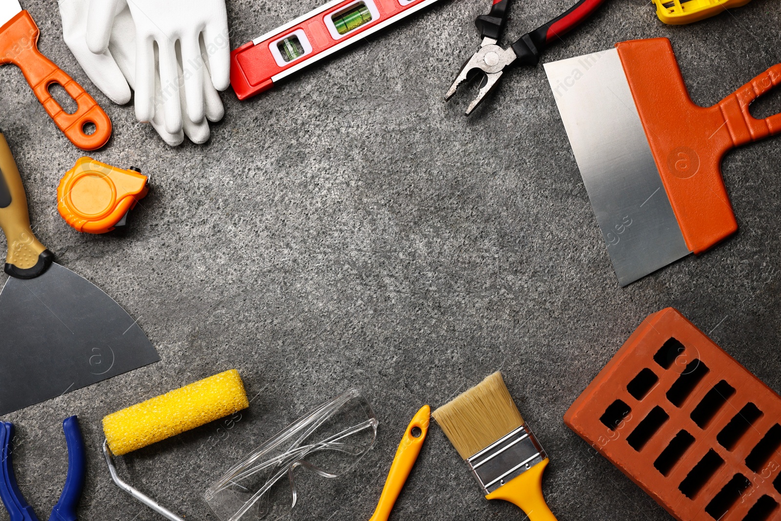 Photo of Frame made of different construction materials and tools on grey table, flat lay. Space for text