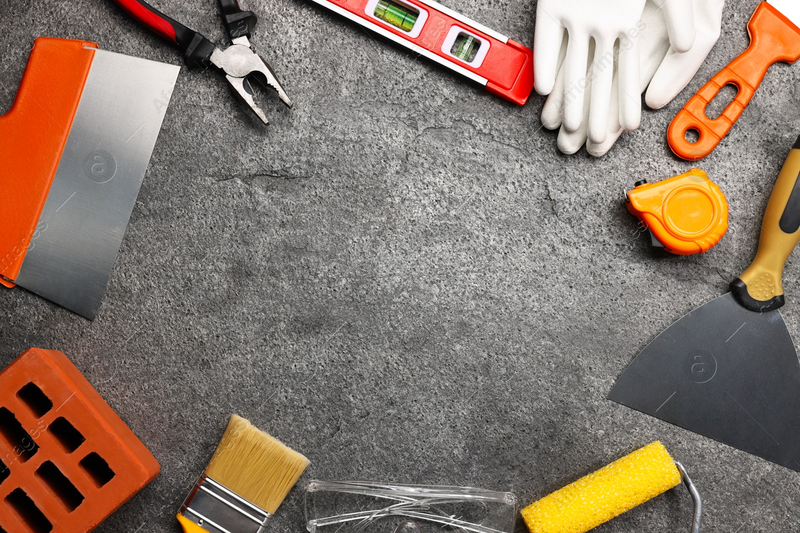 Photo of Frame made of different construction materials and tools on grey table, flat lay. Space for text