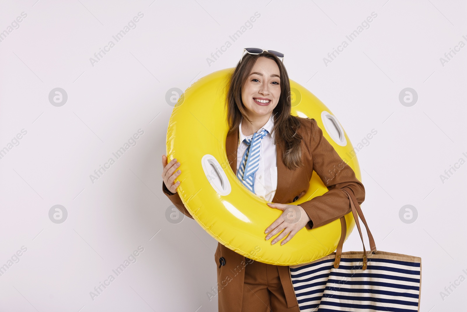 Photo of Businesswoman with inflatable ring, bag and sunglasses on white background