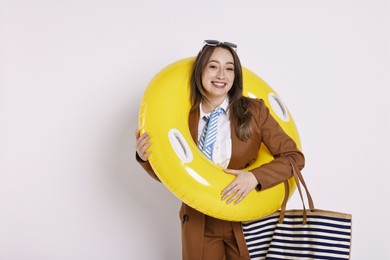 Photo of Businesswoman with inflatable ring, bag and sunglasses on white background