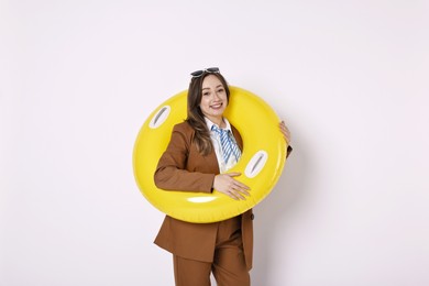 Photo of Businesswoman with inflatable ring and sunglasses on white background