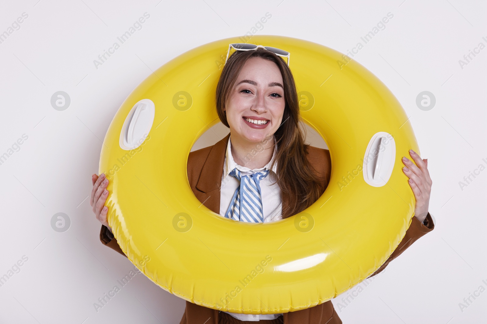 Photo of Businesswoman with inflatable ring and sunglasses on white background