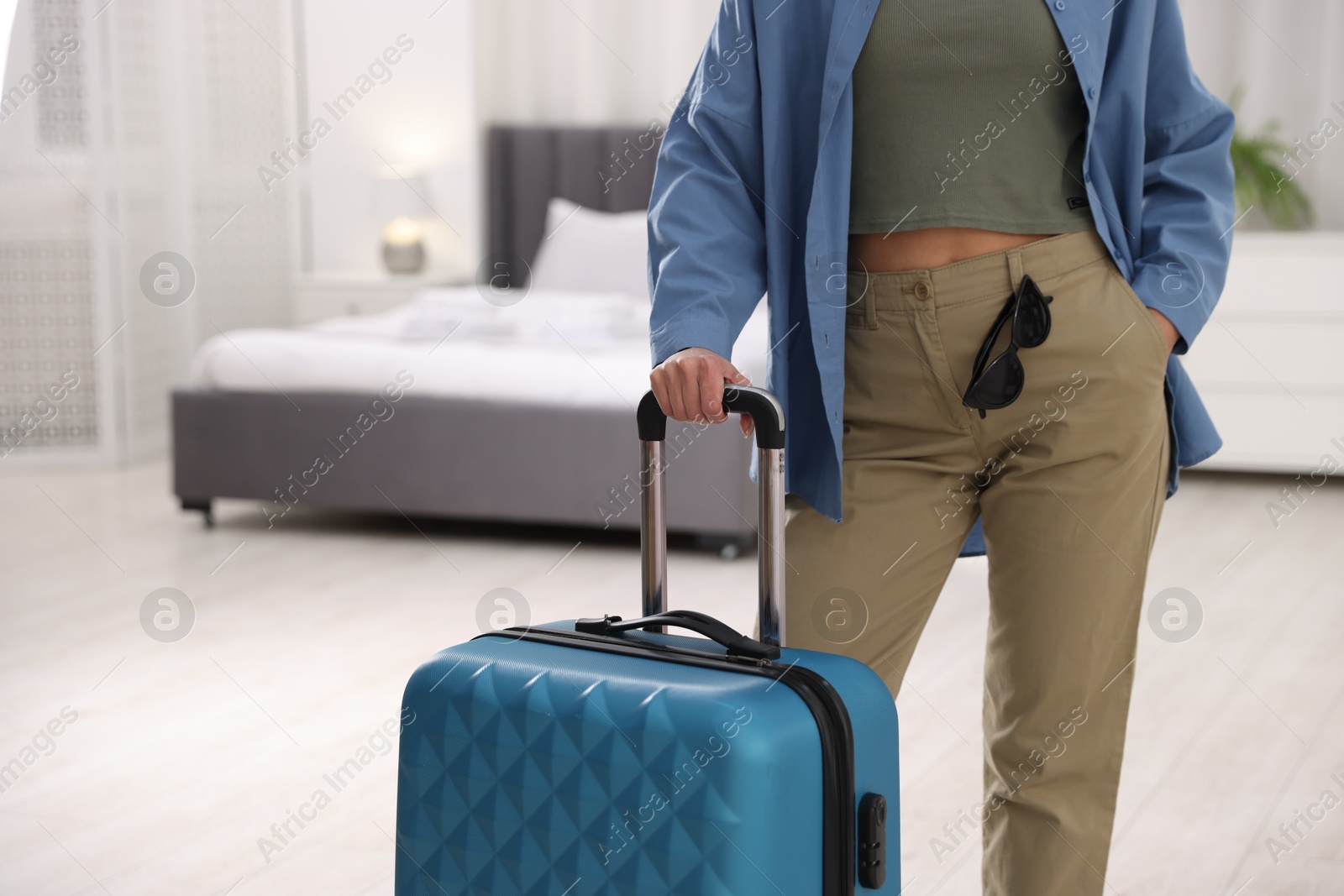 Photo of Woman with suitcase in hotel room, closeup. Space for text