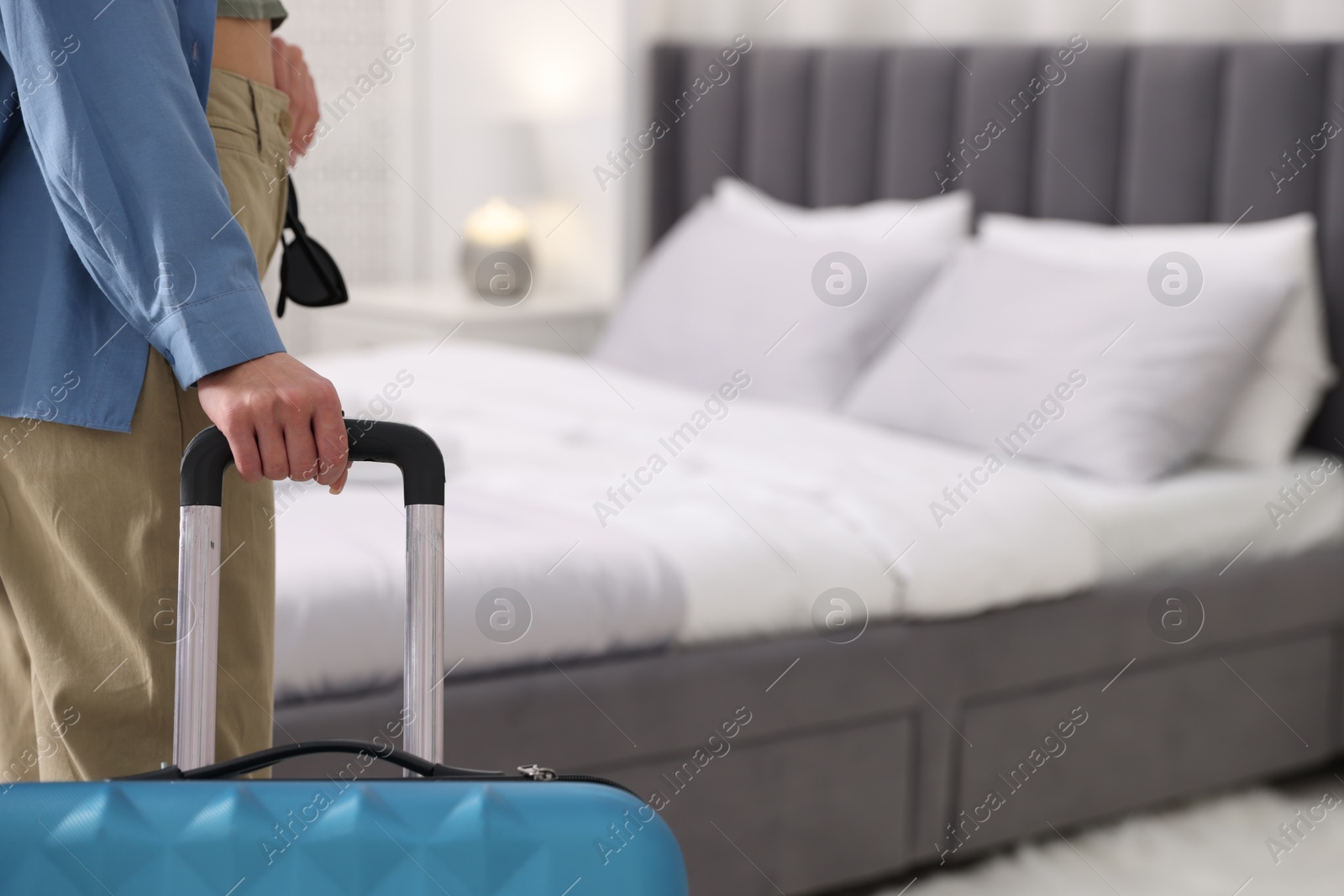 Photo of Woman with suitcase in hotel room, closeup