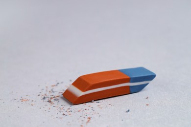 Photo of One eraser and scraps on grey background, closeup