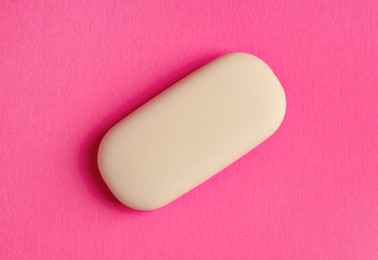 Photo of One eraser on pink background, top view