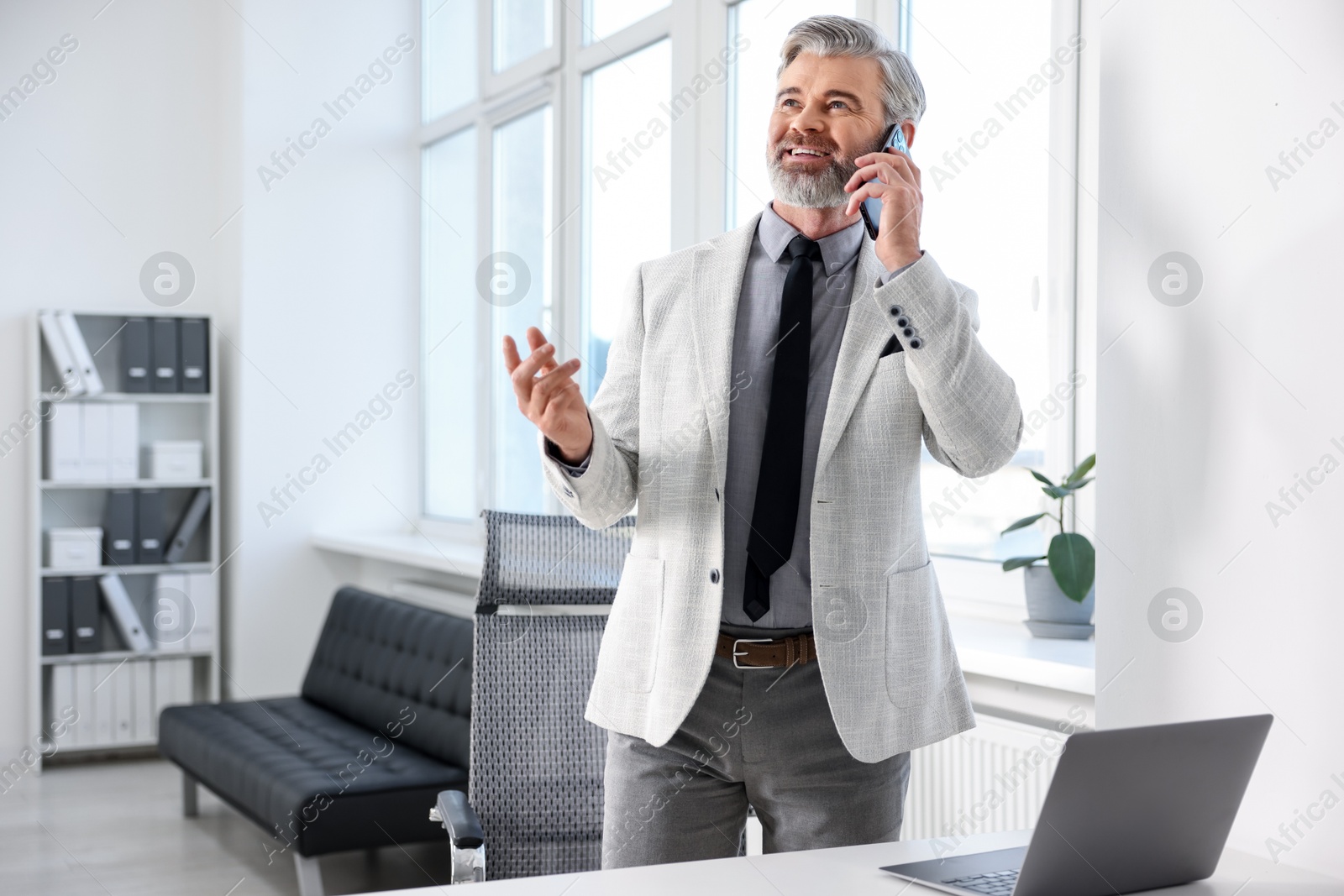 Photo of Banker talking on smartphone in office, space for text