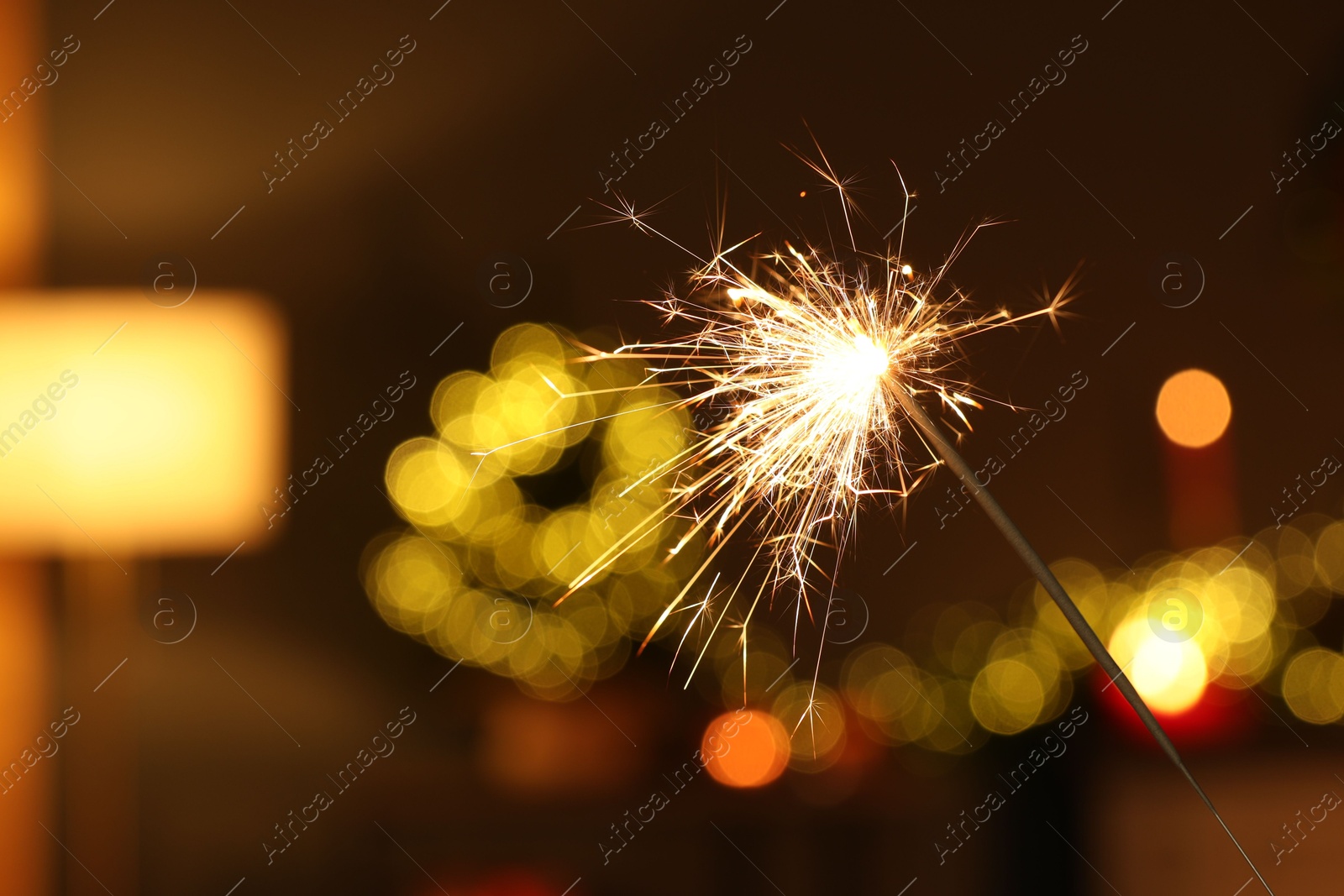 Photo of Bright burning sparkler on blurred background, space for text. Bokeh effect