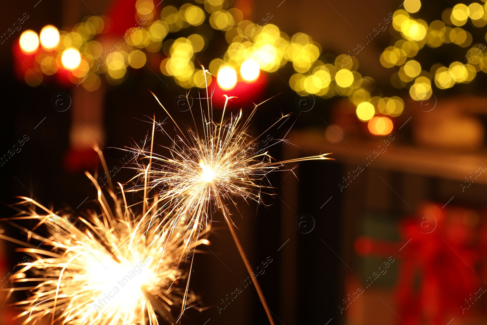 Photo of Bright burning sparklers on blurred background, space for text. Bokeh effect