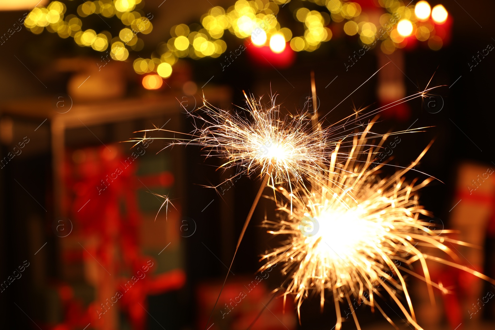 Photo of Bright burning sparklers on blurred background, space for text. Bokeh effect