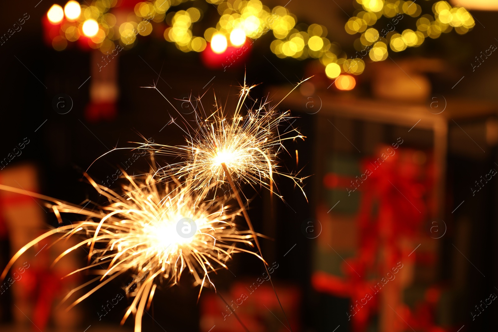 Photo of Bright burning sparklers on blurred background, space for text. Bokeh effect