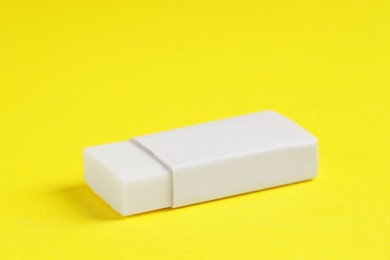 Photo of One eraser on yellow background, closeup view