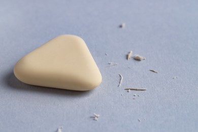 Photo of One eraser and scraps on grey background, closeup