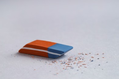 Photo of One eraser and scraps on grey background, closeup