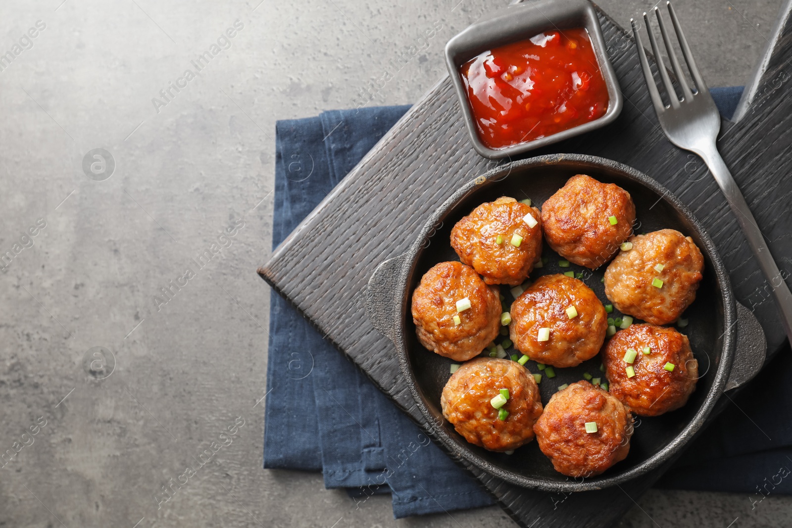 Photo of Tasty meatballs in baking dish served on grey table, flat lay. Space for text