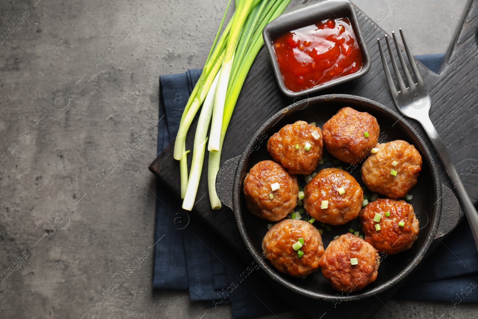 Photo of Tasty meatballs in baking dish served on grey table, flat lay. Space for text