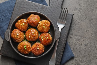 Photo of Tasty meatballs served on grey table, flat lay