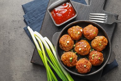 Photo of Tasty meatballs served on grey table, flat lay