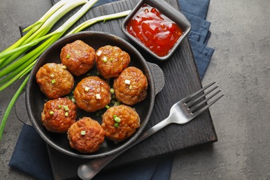 Photo of Tasty meatballs served on grey table, flat lay