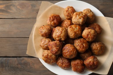 Photo of Many delicious meatballs on wooden table, top view. Space for text