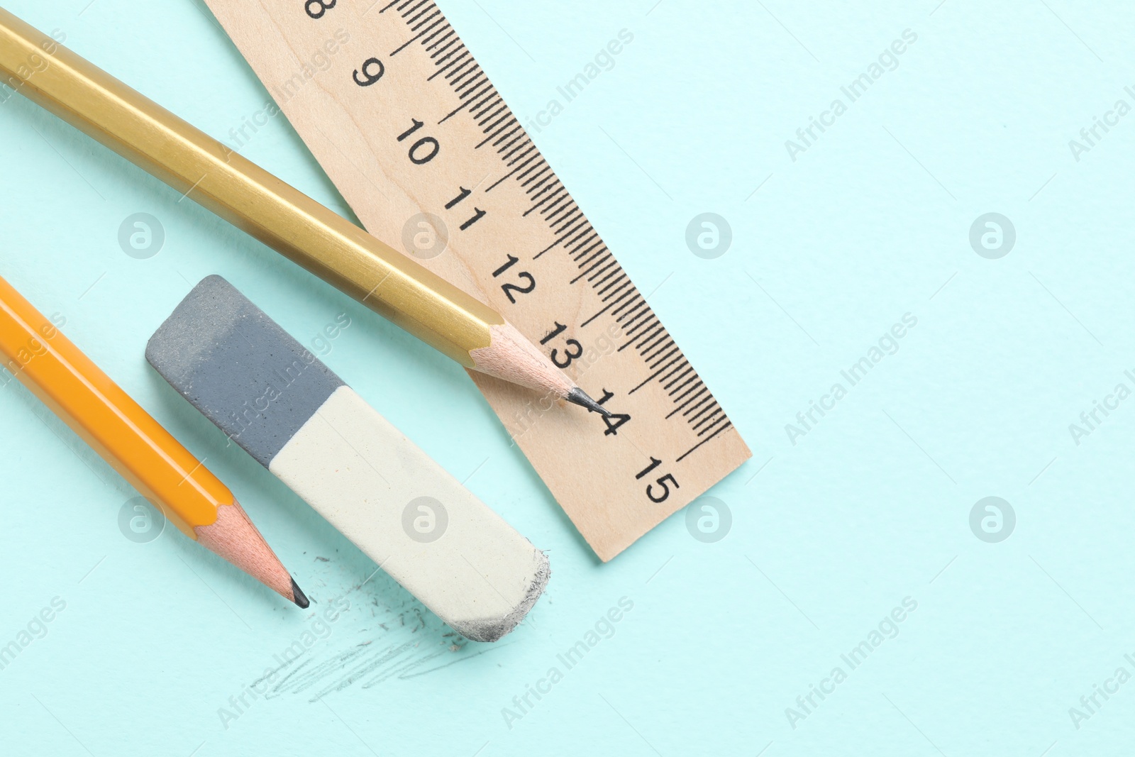 Photo of Eraser, pencils and ruler on light blue background, flat lay. Space for text