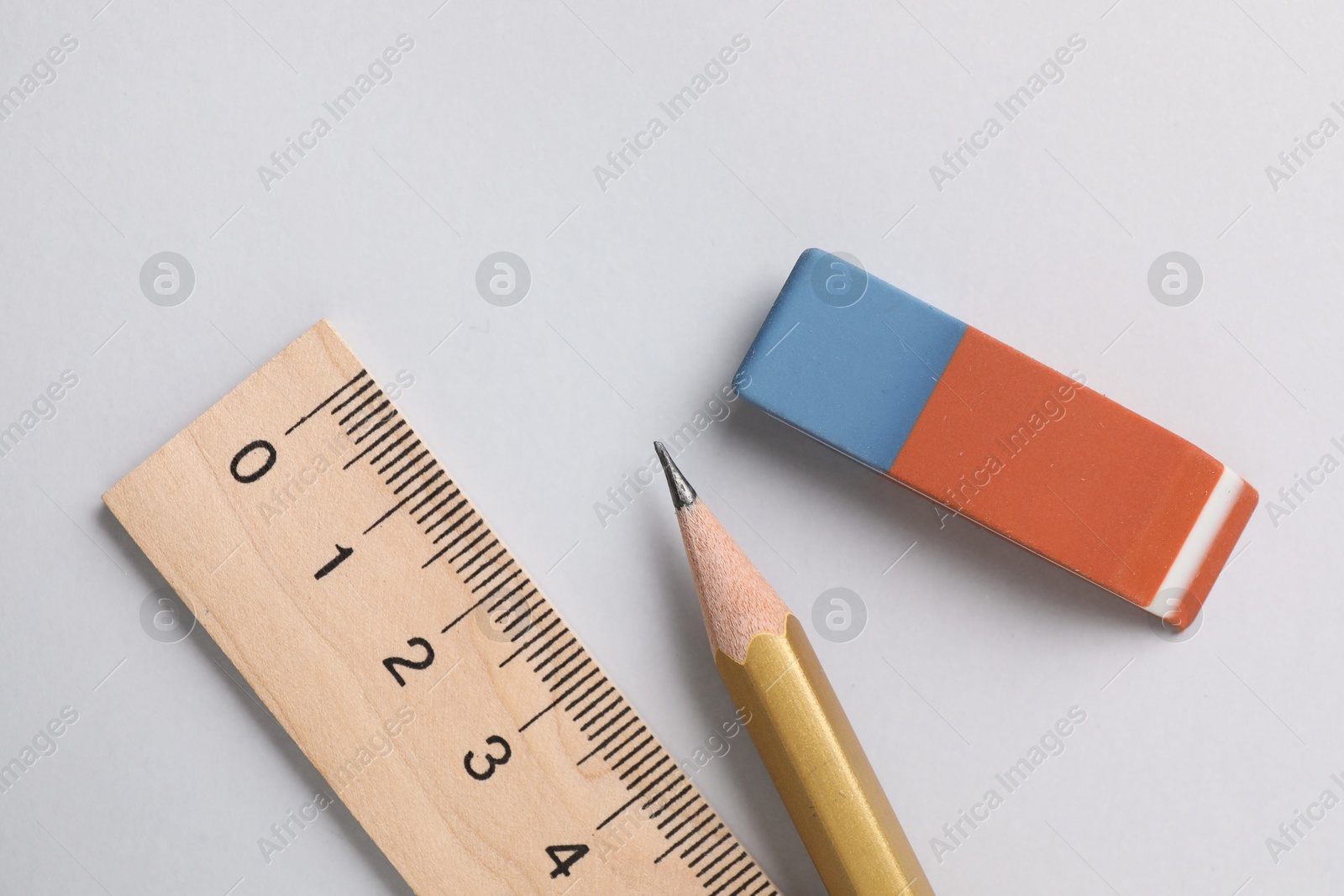 Photo of Eraser, pencil and ruler on light background, top view