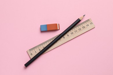 Photo of Eraser, ruler and pencil on pink background, flat lay