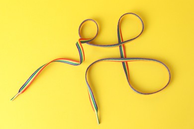 Photo of Shoelace in LGBT colors on yellow background, top view