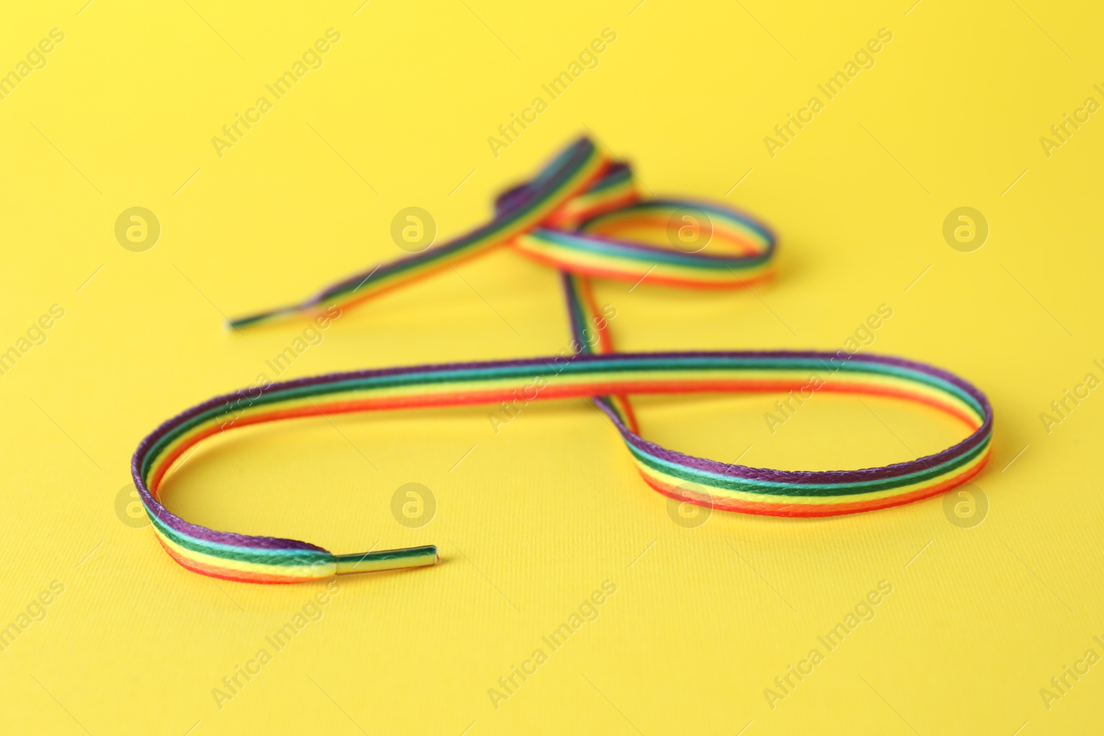 Photo of Shoelace in LGBT colors on yellow background, closeup