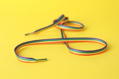 Photo of Shoelace in LGBT colors on yellow background, closeup