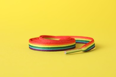 Photo of Shoelace in LGBT colors on yellow background, closeup