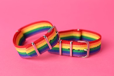 Photo of Two wristbands in LGBT colors on pink background, closeup