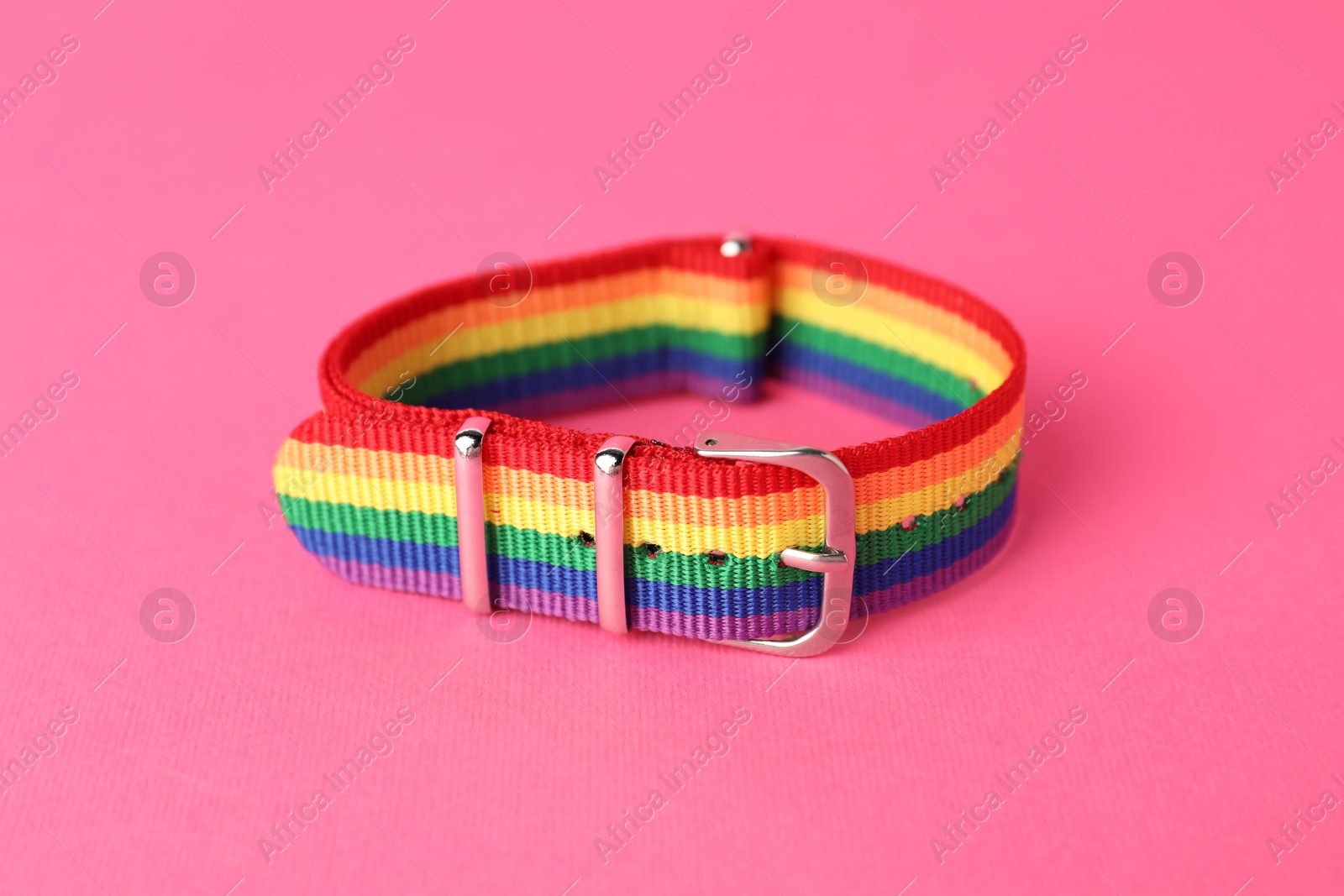 Photo of One wristband in LGBT colors on pink background, closeup