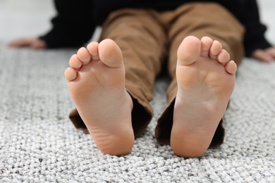 Photo of Little boy on soft carpet indoors, closeup